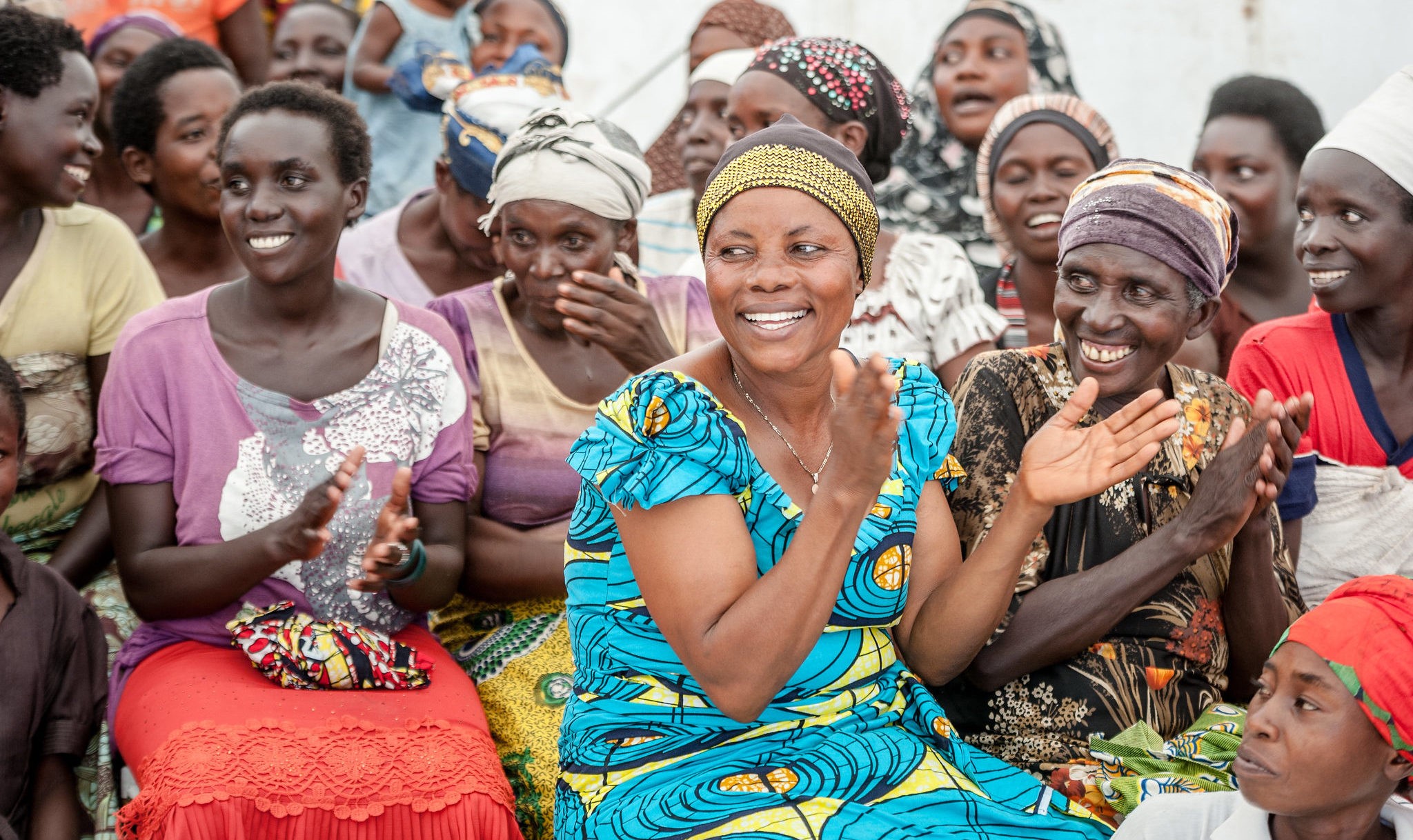 Featured image showing a group of women wearing colorful dresses in community activity.
